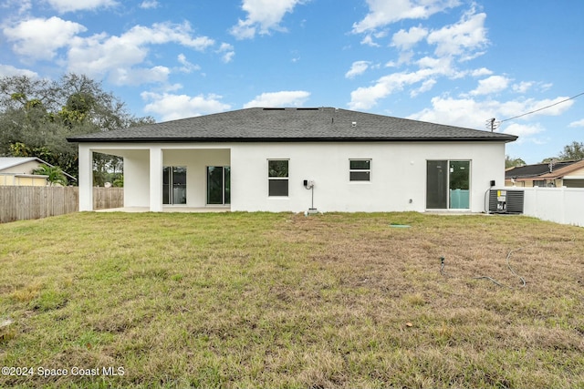 rear view of property featuring a patio area and a yard