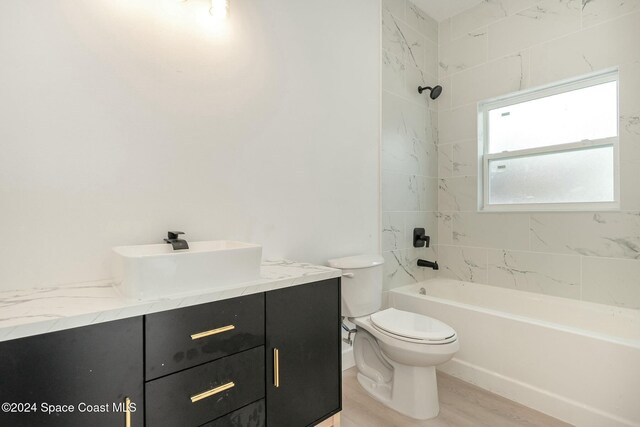 full bathroom featuring vanity, toilet, tiled shower / bath, and hardwood / wood-style flooring