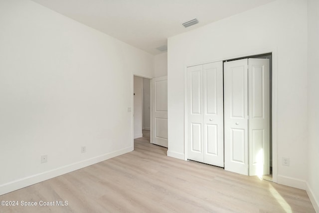 unfurnished bedroom with a closet and light hardwood / wood-style flooring