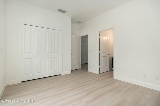 unfurnished bedroom with light hardwood / wood-style floors and a closet