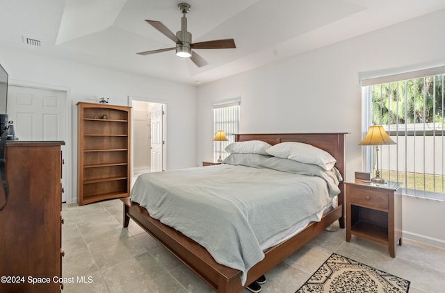 bedroom with a raised ceiling and ceiling fan