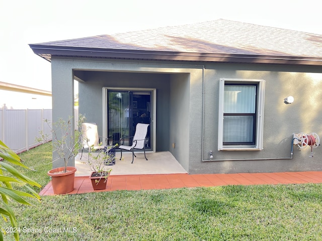 rear view of house with a lawn and a patio area