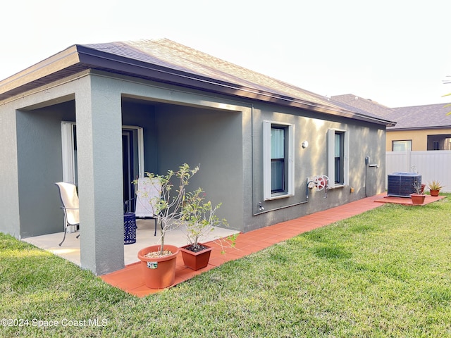 exterior space with a yard, central AC unit, and a patio area