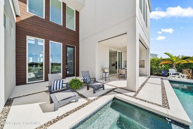 exterior space featuring a patio area and a swimming pool with hot tub