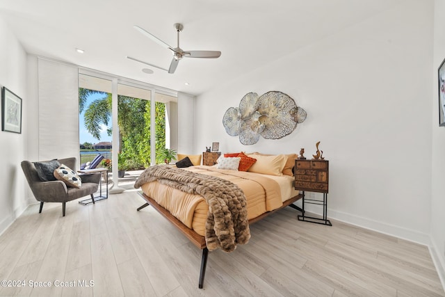 bedroom with floor to ceiling windows, light hardwood / wood-style floors, and ceiling fan