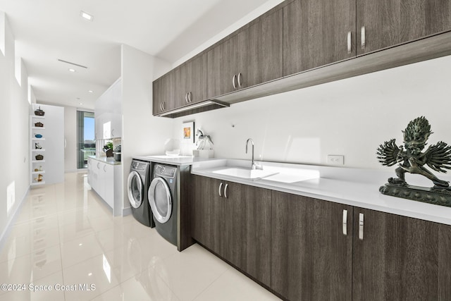 washroom featuring cabinets, light tile patterned flooring, washer and dryer, and sink