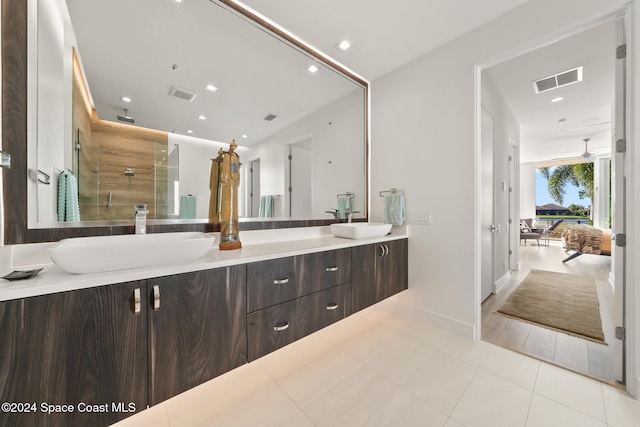 bathroom featuring tile patterned flooring, vanity, and a tile shower