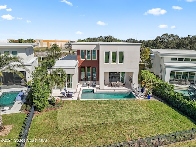 rear view of property featuring a fenced in pool, an outdoor living space, a lawn, and a patio