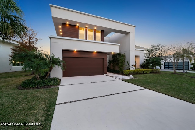 contemporary home featuring a garage and a yard