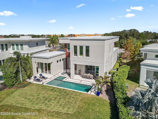 rear view of house with a patio and a lawn