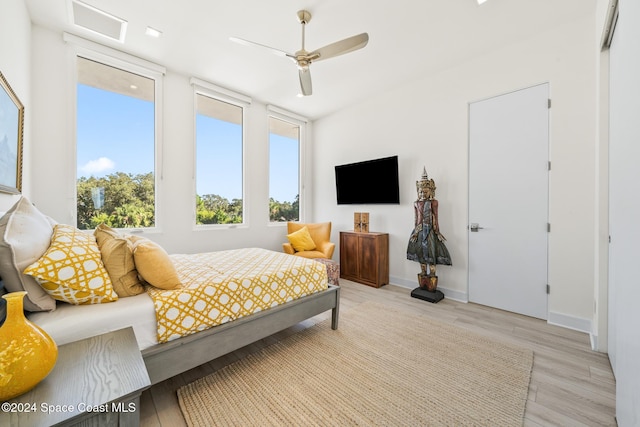 bedroom with light wood-type flooring, multiple windows, and ceiling fan