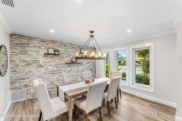 dining area featuring light hardwood / wood-style floors and ornamental molding