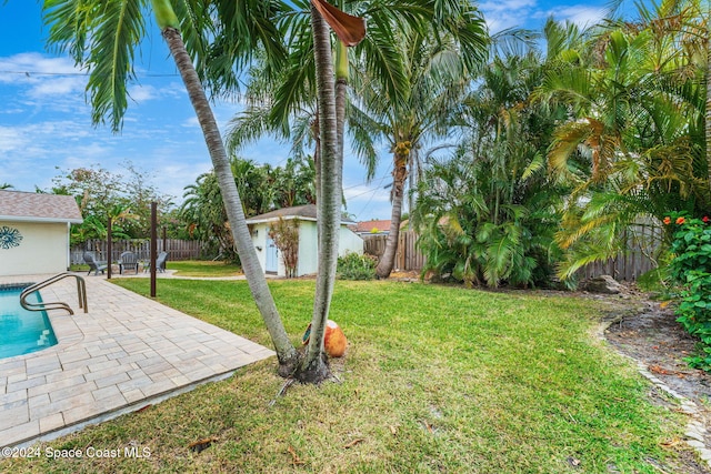 view of yard with a fenced in pool, an outdoor structure, and a patio