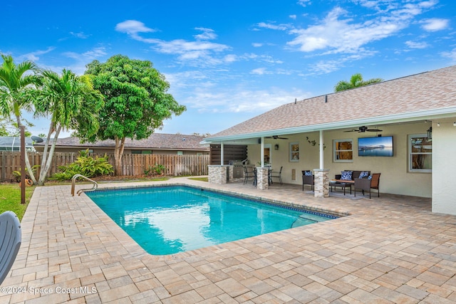 view of swimming pool featuring ceiling fan, a patio area, and exterior kitchen