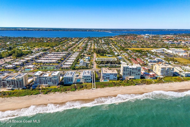 birds eye view of property featuring a water view and a beach view