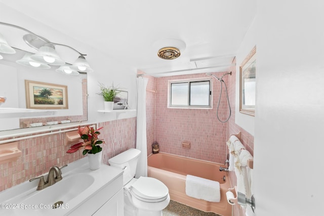 full bathroom with tiled shower / bath combo, toilet, tile walls, and vanity