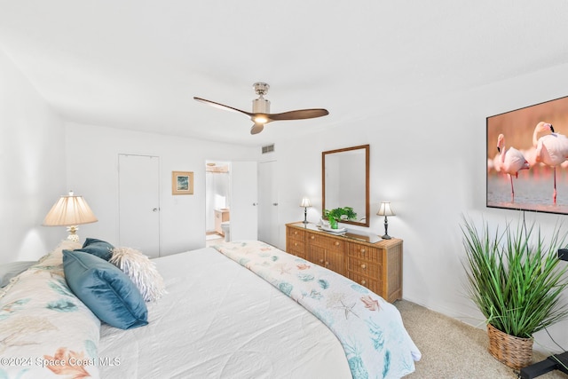 bedroom with light colored carpet, ensuite bath, and ceiling fan