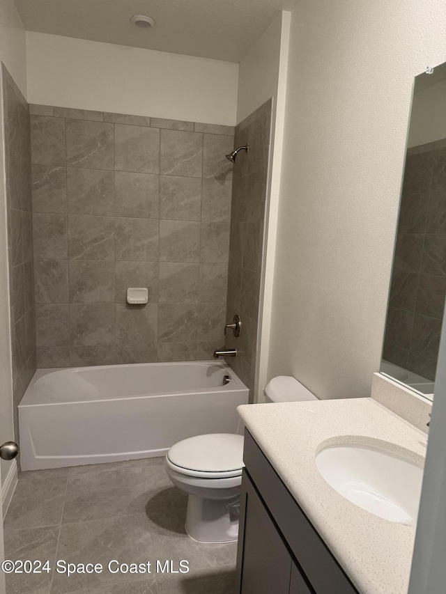 full bathroom featuring tile patterned floors, vanity, toilet, and tiled shower / bath