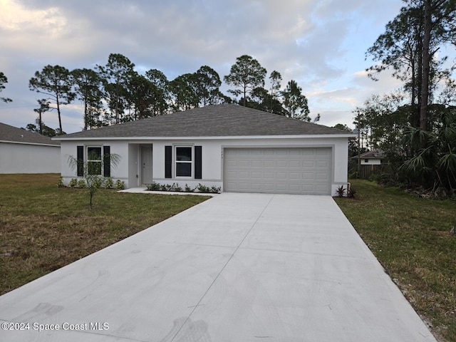 single story home featuring a garage, concrete driveway, a front yard, stucco siding, and a shingled roof