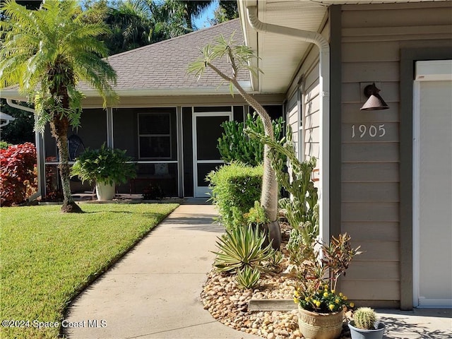 view of exterior entry with a yard