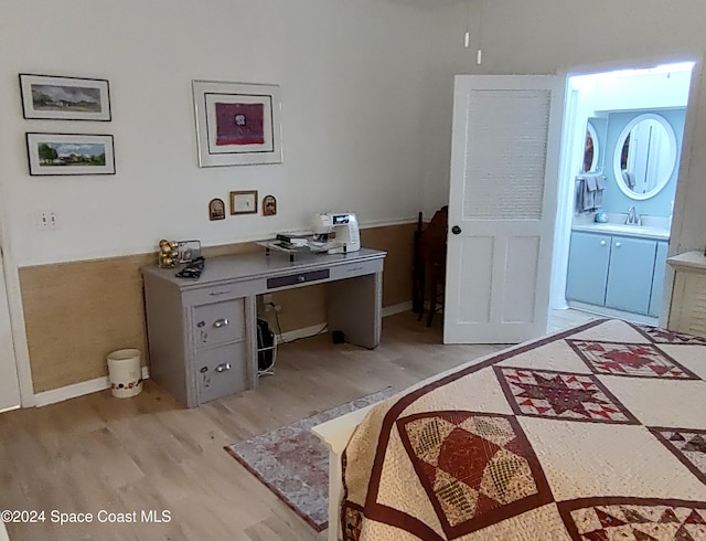 office with light hardwood / wood-style flooring and sink