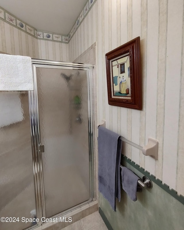 bathroom with tile patterned floors and a shower with door