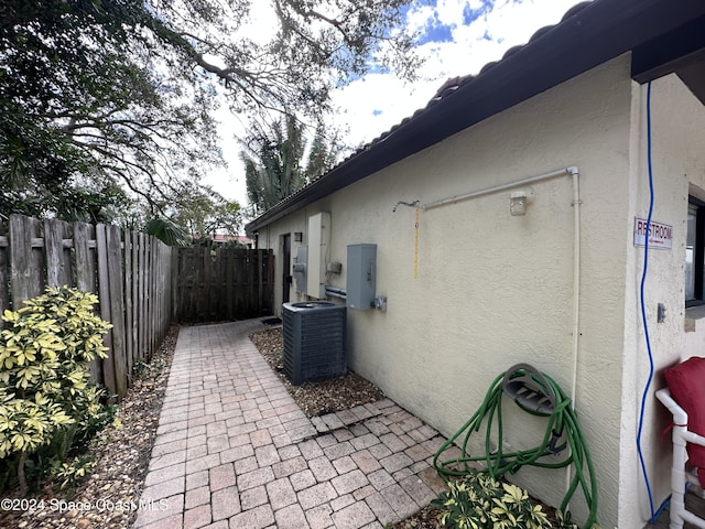 view of home's exterior with a patio area, central air condition unit, and electric panel