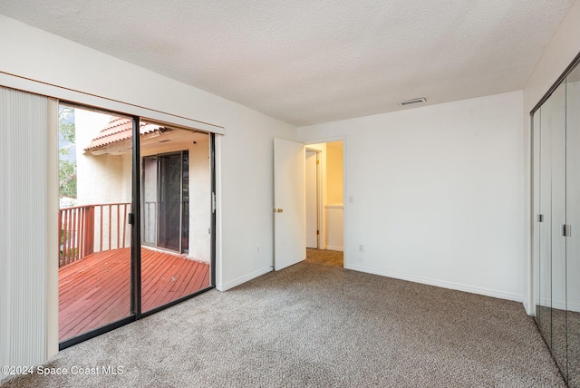 unfurnished bedroom featuring carpet floors, a textured ceiling, and a closet