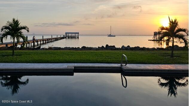 dock area with a yard and a water view