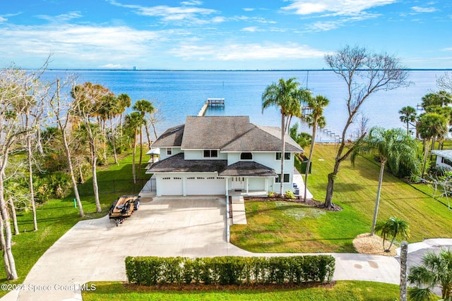 view of front of house with a garage, a water view, and a front lawn