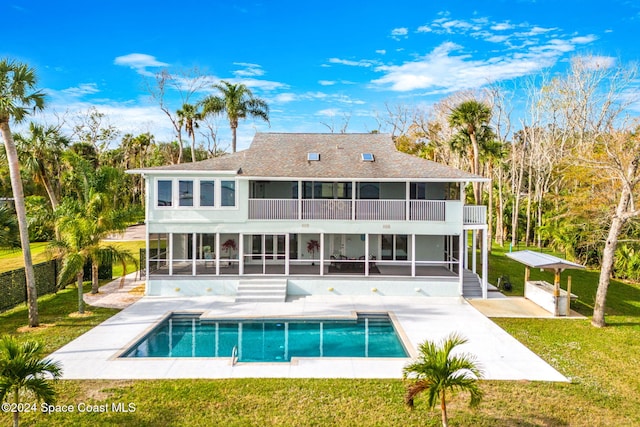 back of property with a patio area, a sunroom, a lawn, and a balcony