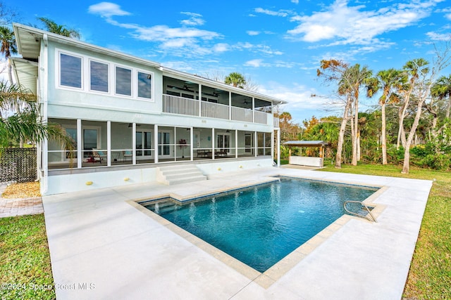 view of swimming pool with a patio area and a sunroom