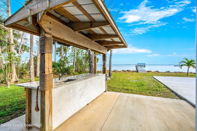 view of patio with sink and a water view