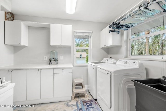 laundry room featuring cabinets, washer and clothes dryer, and sink