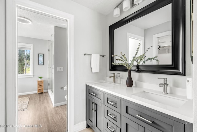 bathroom featuring vanity, walk in shower, a textured ceiling, and hardwood / wood-style floors