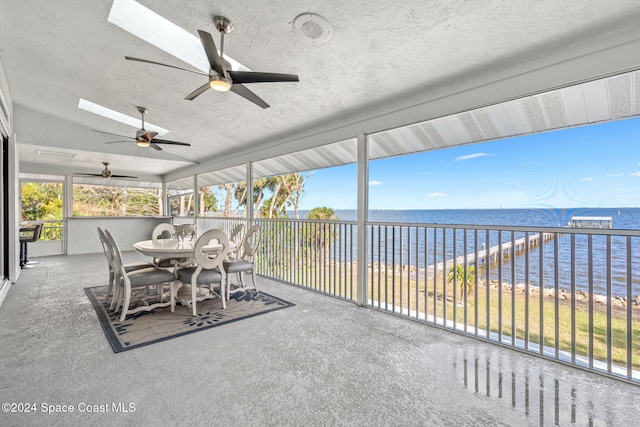 sunroom featuring vaulted ceiling and a water view