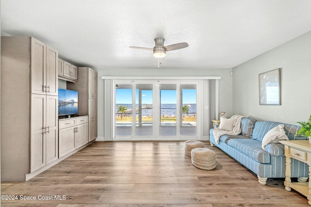 living room with ceiling fan, hardwood / wood-style floors, and a textured ceiling