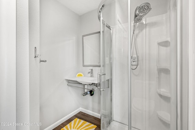 bathroom with hardwood / wood-style floors and an enclosed shower