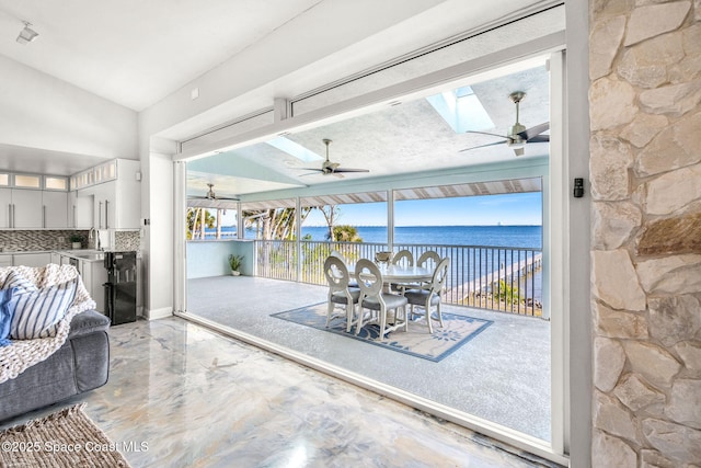 view of patio / terrace with sink, ceiling fan, and a water view