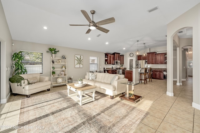 tiled living room with ceiling fan and lofted ceiling