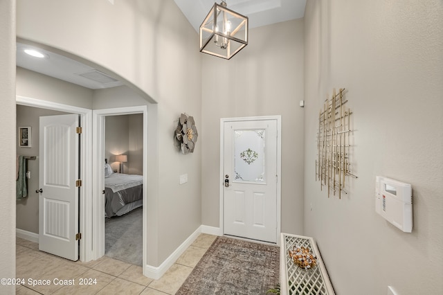 tiled entryway featuring a chandelier