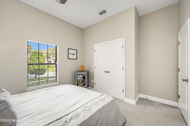 bedroom featuring light carpet, a closet, and ceiling fan