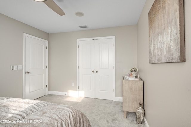 carpeted bedroom featuring a closet and ceiling fan