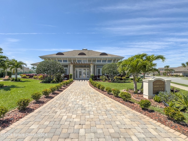 view of front of home with french doors and a front lawn