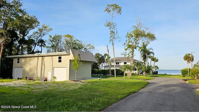 100 Bonita St, Titusville, FL 32780 - view of property exterior with a garage, a yard, a water view, and an outbuilding