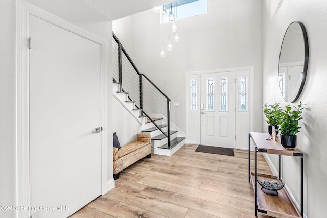 100 Bonita St, Titusville, FL 32780 - foyer entrance with light wood-style flooring, stairway, plenty of natural light, and a high ceiling