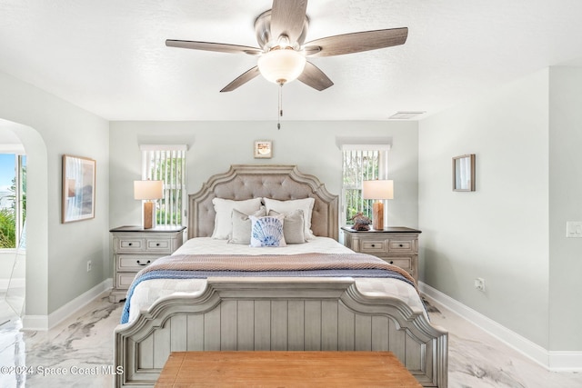 100 Bonita St, Titusville, FL 32780 - bedroom featuring light marble finish floors, multiple windows, arched walkways, and ceiling fan