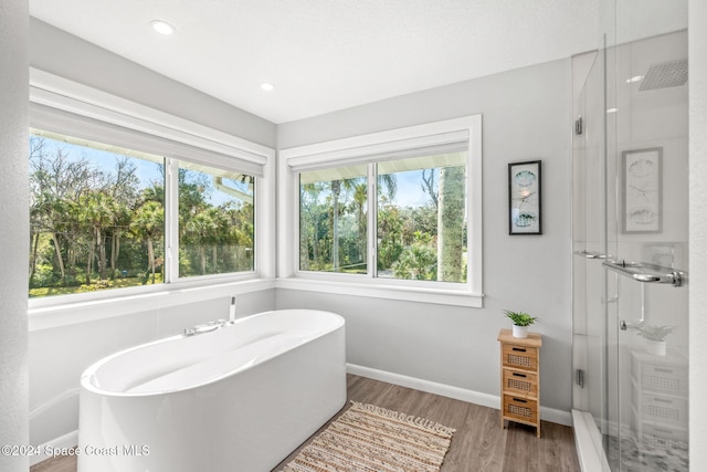 100 Bonita St, Titusville, FL 32780 - full bath with a freestanding bath, wood finished floors, a stall shower, and recessed lighting