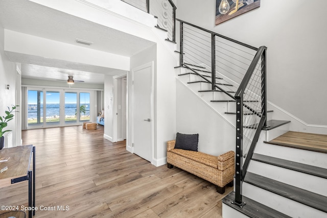100 Bonita St, Titusville, FL 32780 - stairway featuring wood finished floors, a ceiling fan, and a water view
