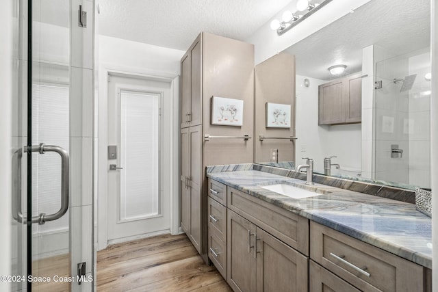 100 Bonita St, Titusville, FL 32780 - full bath featuring vanity, wood finished floors, a stall shower, and a textured ceiling